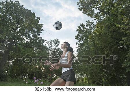 Stock Image - young woman practising football. Fotosearch