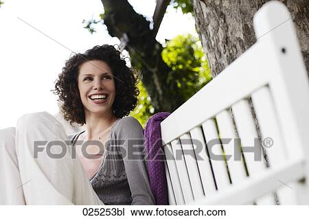 young woman sitting on garden bench View Large Photo Image Stock Image - young woman sitting on garden bench. Fotosearch