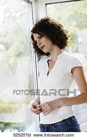 young woman standing by the window View Large Photo Image Stock Image - young woman standing by the window. Fotosearch
