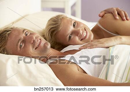幸せな カップル 抱きしめること ベッドに ストックイメージ Bn Fotosearch