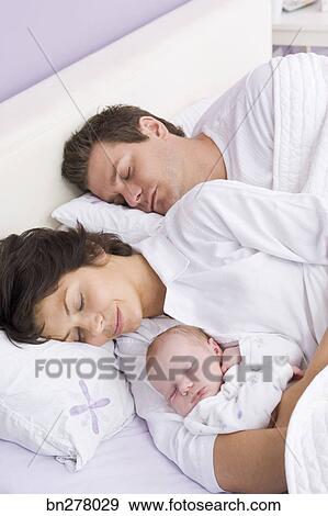 baby sleeping in bed with parents