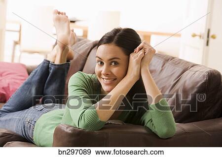 Smiling Woman Lying Down On Couch Stock Photo Bn297089 Fotosearch