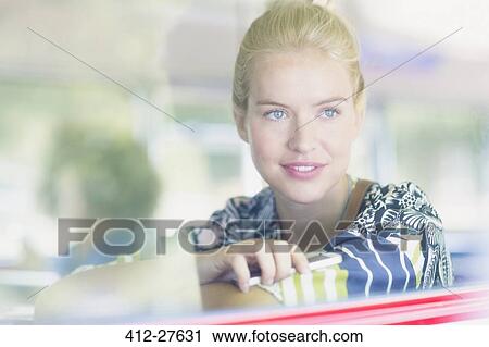 Stock Image - Blonde woman looking out window on bus. Fotosearch