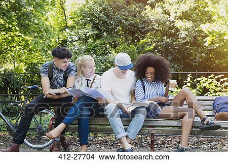College students hanging out studying on park bench View Large Photo Image Picture - College students hanging out studying on park bench. Fotosearch
