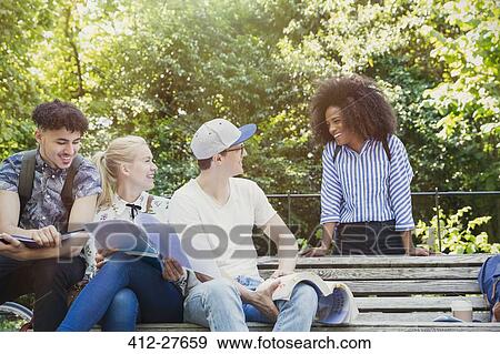 College students hanging out studying on park bench View Large Photo Image Stock Photo - College students hanging out studying on park bench. Fotosearch