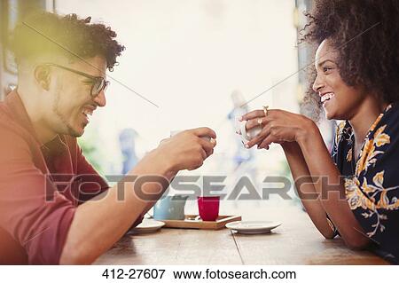 Couple drinking coffee face to face in cafe View Large Photo Image Stock Photo - Couple drinking coffee face to face in cafe. Fotosearch