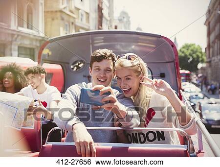 Couple taking selfie on double-decker bus, London, United Kingdom View Large Photo Image Stock Photograph - Couple taking selfie on double-decker bus, London, United Kingdom. Fotosearch