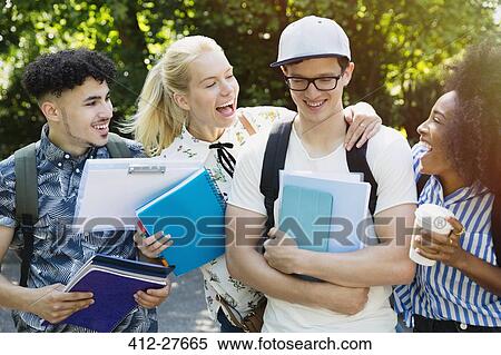 Stock Photography - Enthusiastic college students joking friend outside. Fotosearch