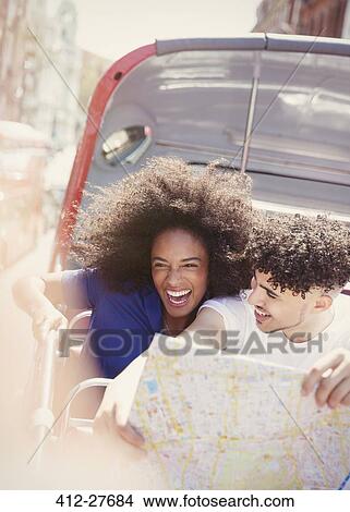 Enthusiastic couple with map on double-decker bus View Large Photo Image Picture - Enthusiastic couple with map on double-decker bus. Fotosearch