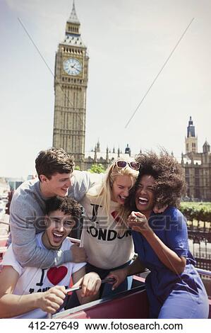 Enthusiastic friends riding double-decker bus below Big Ben clocktower, London, United Kingdom View Large Photo Image Stock Photo - Enthusiastic friends riding double-decker bus below Big Ben clocktower, London, United Kingdom. Fotosearch
