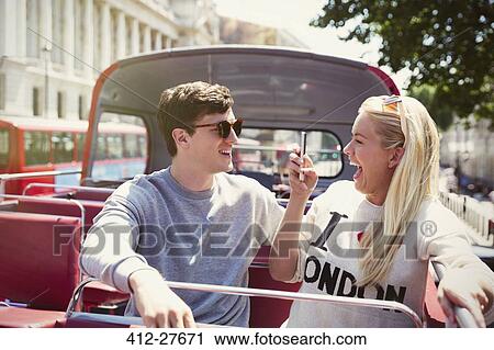 Enthusiastic girlfriend photographing boyfriend on double-decker bus View Large Photo Image Stock Image - Enthusiastic girlfriend photographing boyfriend on double-decker bus. Fotosearch