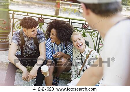 Friends hanging out in park View Large Photo Image Stock Image - Friends hanging out in park. Fotosearch
