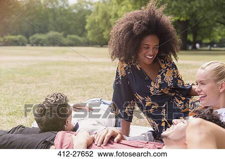 Friends hanging out relaxing on blanket in park View Large Photo Image Stock Image - Friends hanging out relaxing on blanket in park. Fotosearch