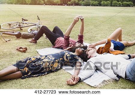 Friends relaxing and taking selfie in circle on blanket in park View Large Photo Image Stock Image - Friends relaxing and taking selfie in circle on blanket in park. Fotosearch