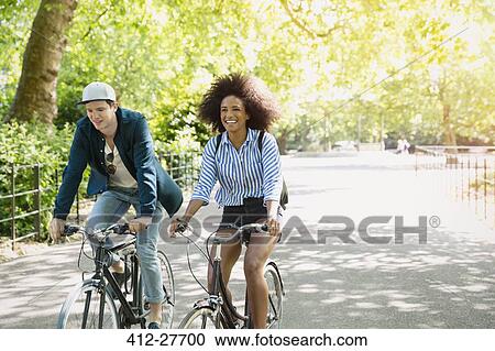 Friends riding bicycles in park View Large Photo Image Stock Image - Friends riding bicycles in park. Fotosearch
