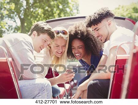 Friends texting with cell phone on double-decker bus View Large Photo Image Stock Image - Friends texting with cell phone on double-decker bus. Fotosearch