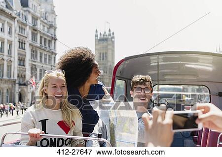 Friends with map riding double-decker bus, London, United Kingdom View Large Photo Image Stock Photo - Friends with map riding double-decker bus, London, United Kingdom. Fotosearch