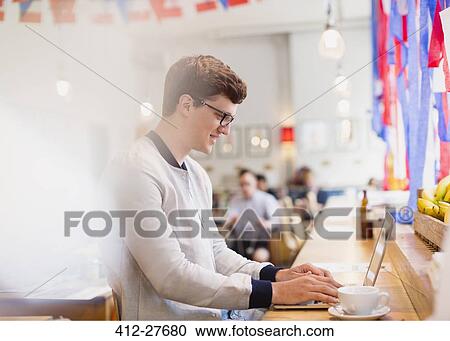 Man using laptop in cafe View Large Photo Image Stock Image - Man using laptop in cafe. Fotosearch