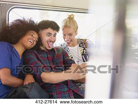 Playful friends taking selfie making faces on bus View Large Photo Image Picture - Playful friends taking selfie making faces on bus. Fotosearch