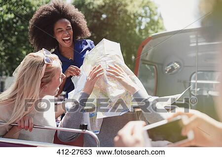Playful friends with map on double-decker bus View Large Photo Image Stock Image - Playful friends with map on double-decker bus. Fotosearch