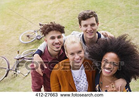 Portrait smiling friends hugging in park View Large Photo Image Stock Image - Portrait smiling friends hugging in park. Fotosearch