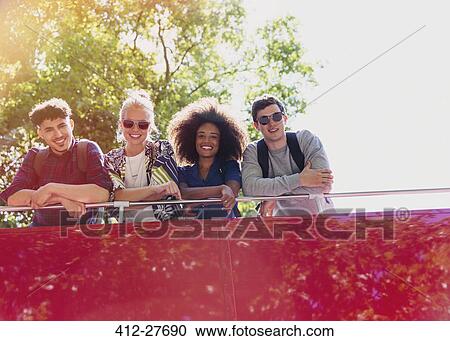 Stock Image - Portrait smiling friends riding double-decker bus. Fotosearch