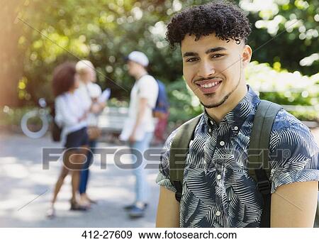 Stock Photo - Portrait smiling man with curly black hair in park. Fotosearch