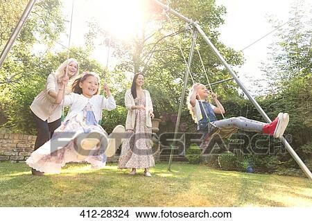 Carefree multi-generation women swinging in backyard View Large Photo Image Picture - Carefree multi-generation women swinging in backyard. Fotosearch