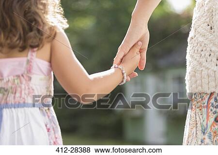 Close up rear view mother and daughter holding hands View Large Photo Image Stock Photo - Close up rear view mother and daughter holding hands. Fotosearch