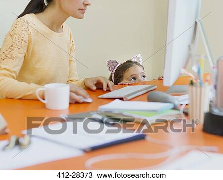 Girl in mouse ears headband watching mother work at computer View Large Photo Image Stock Image - Girl in mouse ears headband watching mother work at computer. Fotosearch
