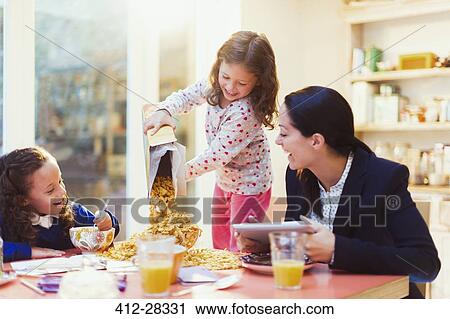 Girl pouring abundance of cereal at breakfast table View Large Photo Image Stock Image - Girl pouring abundance of cereal at breakfast table. Fotosearch