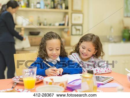 Girls doing homework at breakfast table View Large Photo Image Stock Photo - Girls doing homework at breakfast table. Fotosearch