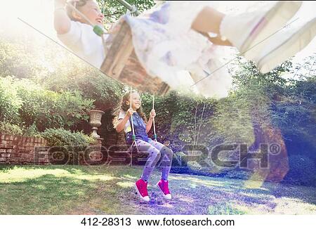 Girls Swinging In Backyard Stock Image 412 28313 Fotosearch