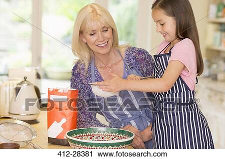 Grandmother and granddaughter baking sifting flour in kitchen View Large Photo Image Stock Image - Grandmother and granddaughter baking sifting flour in kitchen. Fotosearch
