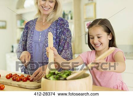 Grandmother and granddaughter preparing salad in kitchen View Large Photo Image Picture - Grandmother and granddaughter preparing salad in kitchen. Fotosearch