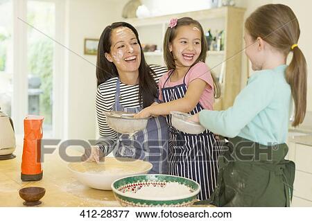 Laughing mother and daughters baking with flour on faces in kitchen View Large Photo Image Stock Photo - Laughing mother and daughters baking with flour on faces in kitchen. Fotosearch
