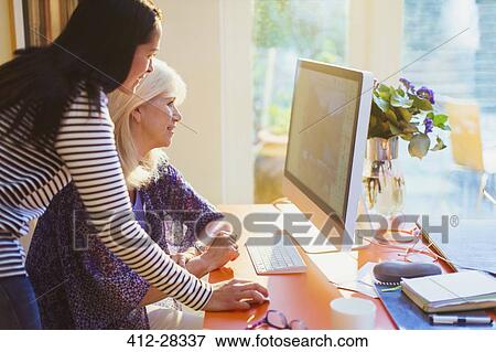 Mother and daughter using computer View Large Photo Image Stock Photo - Mother and daughter using computer. Fotosearch