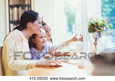 Mother and daughters using computer View Large Photo Image Stock Image - Mother and daughters using computer. Fotosearch