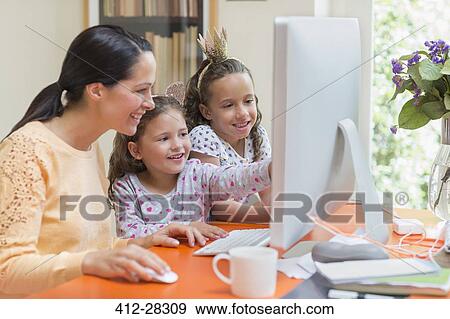 Mother and daughters using computer View Large Photo Image Stock Photo - Mother and daughters using computer. Fotosearch