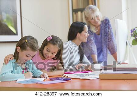 Multi-generation family doing homework and using computer View Large Photo Image Stock Photo - Multi-generation family doing homework and using computer. Fotosearch