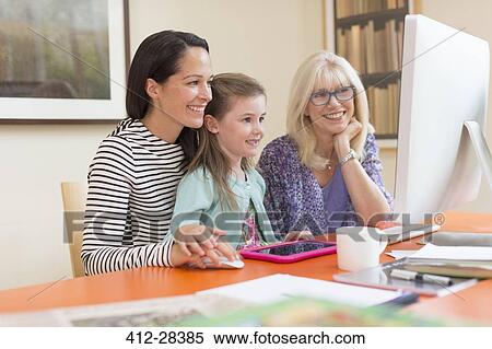 Stock Photography - Multi-generation women using computer. Fotosearch