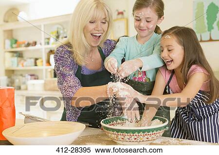 Playful grandmother and granddaughters sprinkling flour in kitchen View Large Photo Image Stock Photography - Playful grandmother and granddaughters sprinkling flour in kitchen. Fotosearch