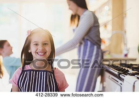 Stock Photo - Portrait enthusiastic girl with toothy smile in kitchen. Fotosearch