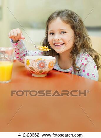 Portrait smiling girl eating cereal at breakfast table View Large Photo Image Stock Image - Portrait smiling girl eating cereal at breakfast table. Fotosearch