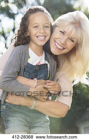 Stock Photo - Portrait smiling grandmother and granddaughter hugging. Fotosearch