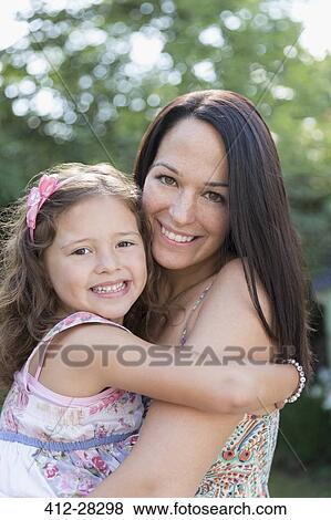 Stock Photo - Portrait smiling mother holding daughter. Fotosearch