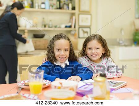 Portrait smiling sisters at breakfast table View Large Photo Image Stock Image - Portrait smiling sisters at breakfast table. Fotosearch