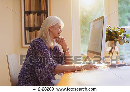 Senior woman working at computer in home office View Large Photo Image Stock Photo - Senior woman working at computer in home office. Fotosearch