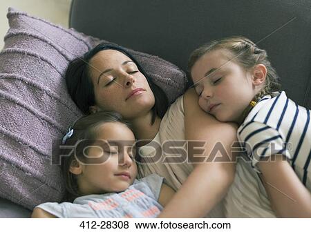 Serene mother and daughters napping on sofa View Large Photo Image Stock Photo - Serene mother and daughters napping on sofa. Fotosearch