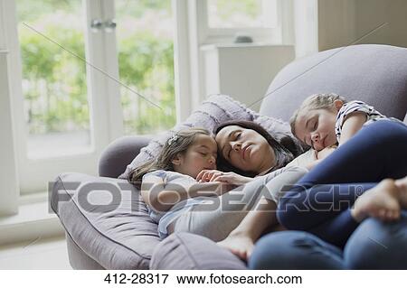 Serene mother and daughters napping on living room sofa View Large Photo Image Stock Photo - Serene mother and daughters napping on living room sofa. Fotosearch